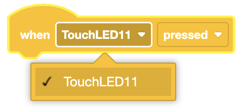 Un bloque con muescas de color amarillo etiquetado 'cuando se presionó TouchLED11' con un menú desplegable expandido para mostrar la opción seleccionada 'TouchLED11' debajo de la selección del sensor.