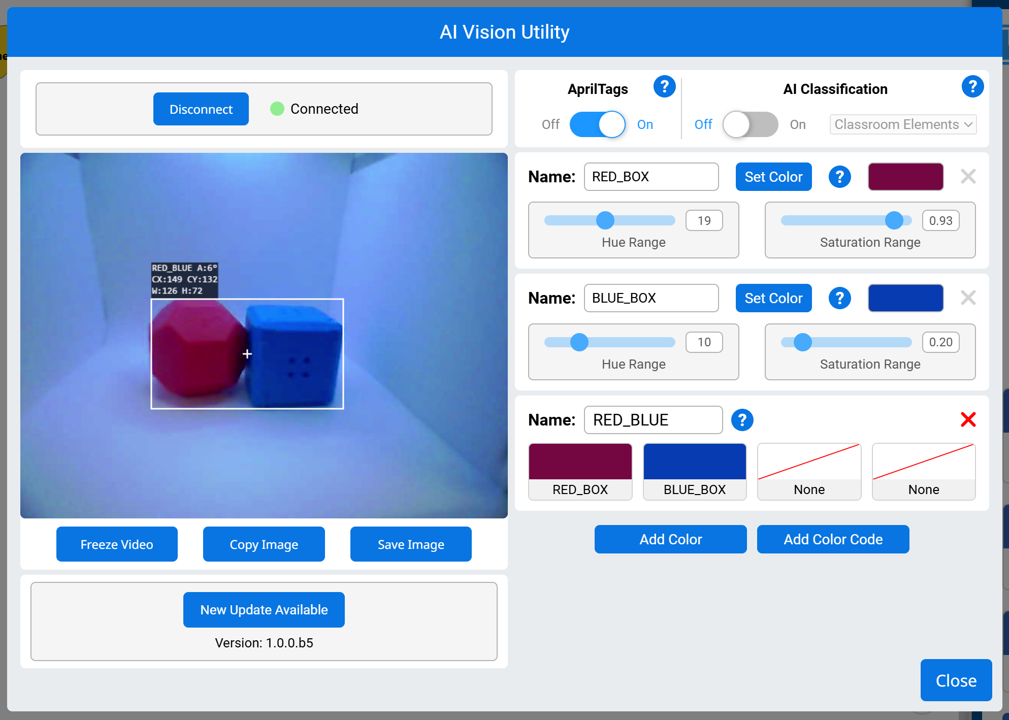 The AI Vision Utility interface shows a connected vision sensor detecting two adjacent objects, a blue box on the left and a red box on the right, grouped together in a single white bounding box labeled BlueRed. Detection information includes angle (A:11°), coordinates (X:143, Y:103), width (W:233), and height (H:108). On the right panel, three color signatures are listed: Red_Box, Blue_Box, and BlueRed, with adjustable hue and saturation ranges. The BlueRed signature combines the Blue_Box and Red_Box. Below the video feed are buttons labeled Freeze Video, Copy Image, Save Image, and Close.