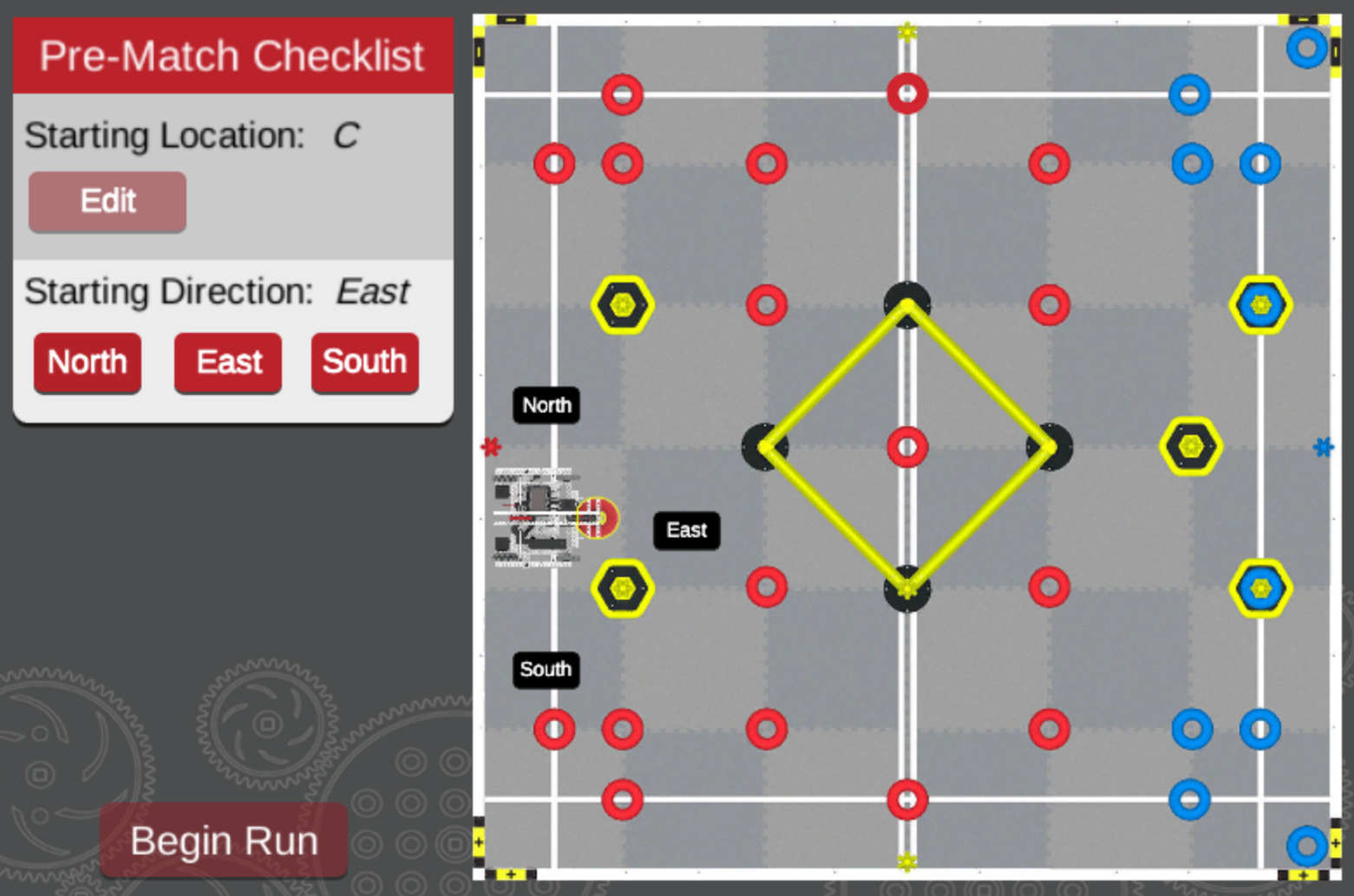 A robotics competition field with a pre-match checklist on the left. The starting location is set to "C," and the starting direction is "East." Buttons for selecting the starting direction (North, East, South) are also visible. Labels for directions ("North," "East," and "South") are marked on the field. The "Begin Run" button is located at the bottom, ready to initiate the match.